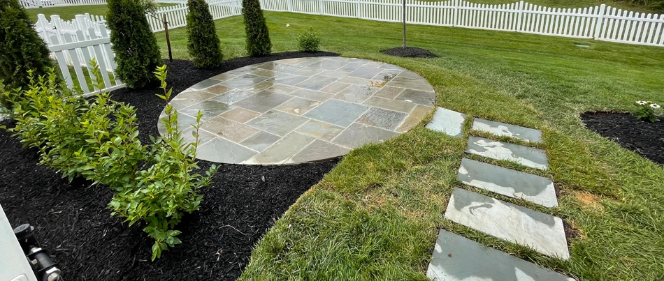 A circular patio in Bristow, VA, with landscaping and outdoor steps.