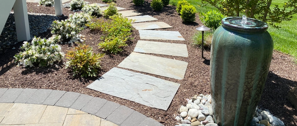 A stone walkway cutting through a landscape to the backyard in Bristow, VA.
