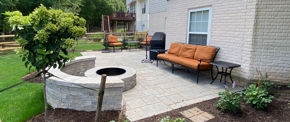 Patio area in Bristow, VA, with a fire pit and seating wall. 